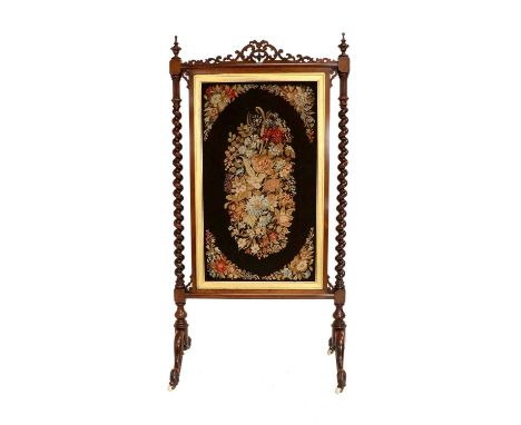 A Victorian Rosewood Firescreen, 3rd quarter 19th century, the floral needlwork panel contained within a gilt border flanked 