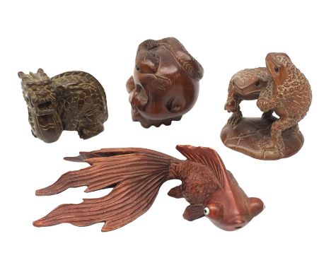 Three Japanese Meiji carved wooden netsukes, comprising dragon, skull with snake, and two frogs on lily pad, together with a 