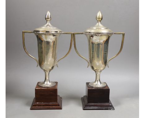 A pair of Royal Hong Kong Jockey Club sterling presentation two handled trophy cups and covers, fixed to wooden plinth bases,