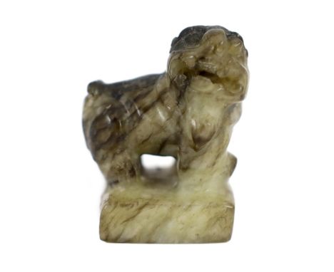 A Chinese pale celadon and black jade ‘lion-dog’ seal, 18th/19th century, the creamy white stone with black inclusions 3.9cm 