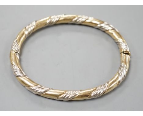 A modern two colour 9ct gold hinged bangle, interior diameter 58mm, 18.7 grams.