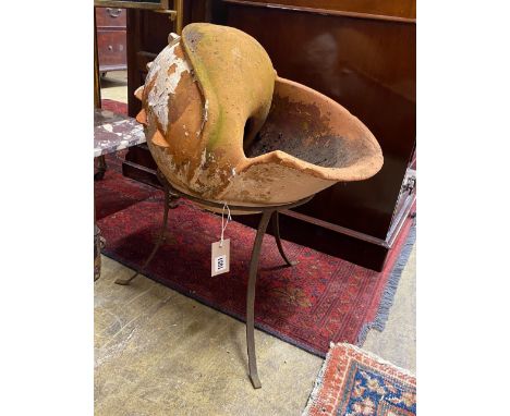 An unusual terracotta garden planter on wrought iron stand modelled as a conch shell, height  56cm