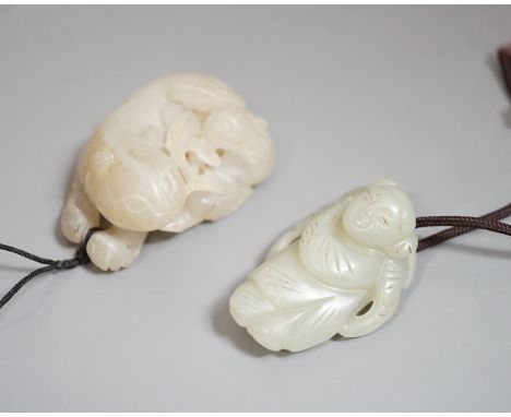 A Chinese pale celadon jade lion dog and cub and a similar figure of a boy, 19th/20th century