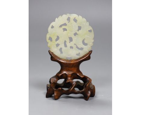 A Chinese jade disc and wood stand, 9cms high