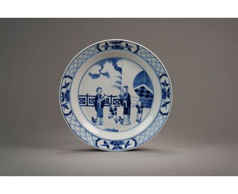 A Chinese blue and white dish Kangxi Of plain circular form and decorated with two ladies and three boys on a palace veranda,