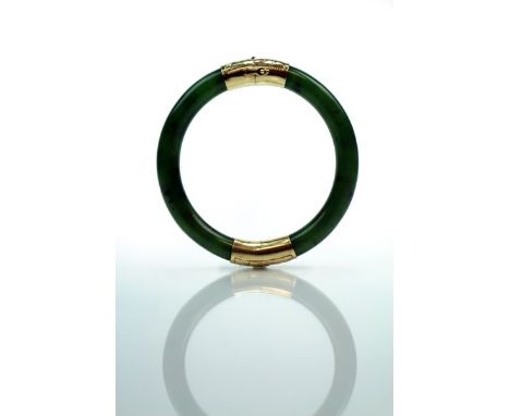 A Chinese mid-green jade and 14k gold bangle Late Qing/Republic The mid-green stone with black inclusions, mounted with 14k g