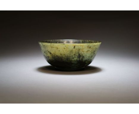 A Chinese mottled grey-green serpentine bowl Qing Dynasty Of elegent inverted bell form raised on a shallow foot ring, the gr