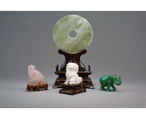 A Group of four Chinese hardstone carvings 19th/20th century Including a pale green jade bi disc carved with stylised lotus f