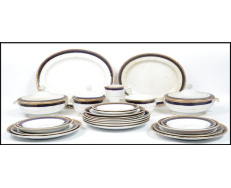 A Mintons tea service, gilded band of foliage above cobalt blue banding, pattern no. 14095, comprising of lidded tureen, plat