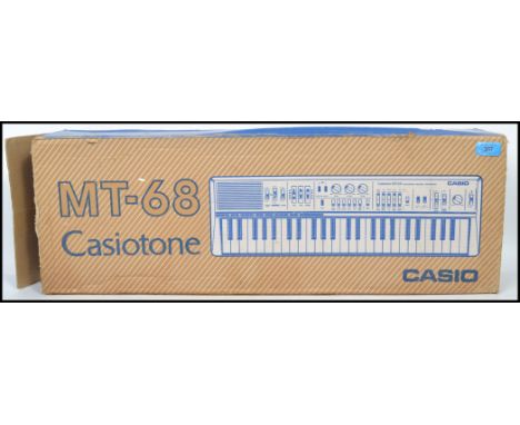 A vintage Casio Casiotone MT-68 electric portable piano complete in original box. Measurements: 7 cm high, 64 cm wide and 19 