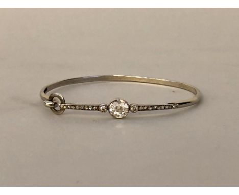 9ct white gold bangle formed from a 19th Century brooch, the white metal brooch element with face set with central 1.25ct tra