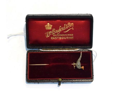 A stick pin, modelled as a pheasant with a red and yellow enamelled head with a cabochon ruby eye and set throughout with old