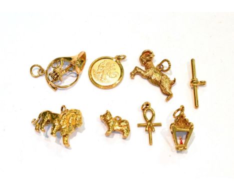 Six 9 carat gold charms including a lion, a dog, a goat, a cross etc; a T-bar stamped '375'; and an unmarked charm of a lante