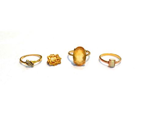 A diamond three stone twist ring, finger size K; two dress rings, finger sizes L1/2 and N; and a brooch, stamped '10K'.  Thre