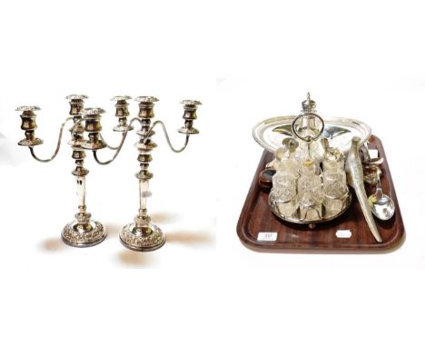 A mixed lot of silver-plate, including: a pair of three-light candelabra; a condiment set with silver-mounted glass bottles; 