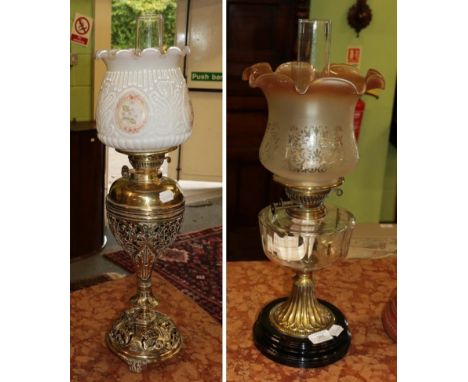 A Victorian pierced brass oil lamp with painted opaque shade; together with a further Victorian oil lamp with glass reservoir