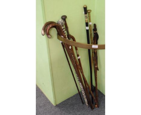 An Edwardian lady's bamboo walking stick with 9 carat gold pommel, two similar examples with silver mounts, a malacca example