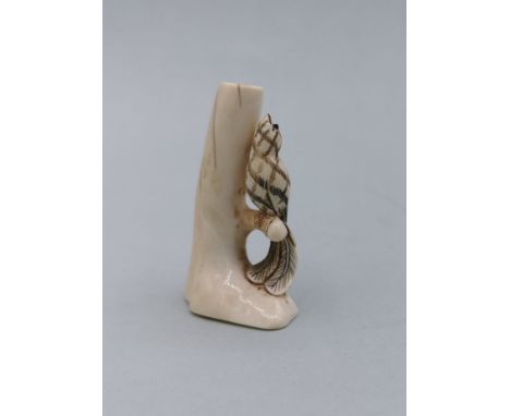 NETSUKE: VOGEL AUF EINEM AST SITZEND / Japanische Schnitzfigur, Asien / Japan, Bein, mit ungedeuteter Signatur. Vollplastisch