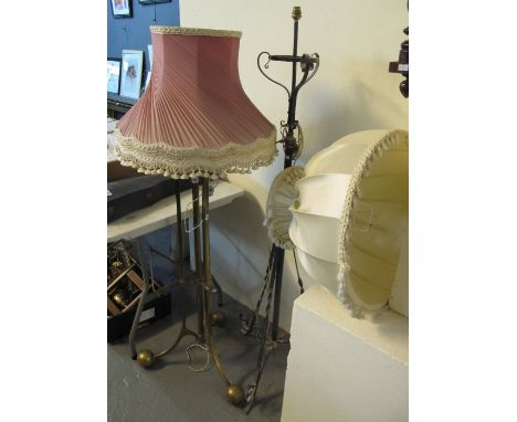 Heavy brass standard lamp on triform base with shade, together with a wrought iron standard lamp on triform base with shade. 