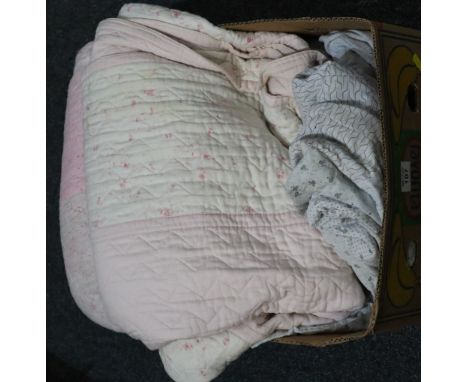 Three vintage quilts to include; a pale blue patchwork quilt, a pink ground floral quilt made of two panels, a pink and flora