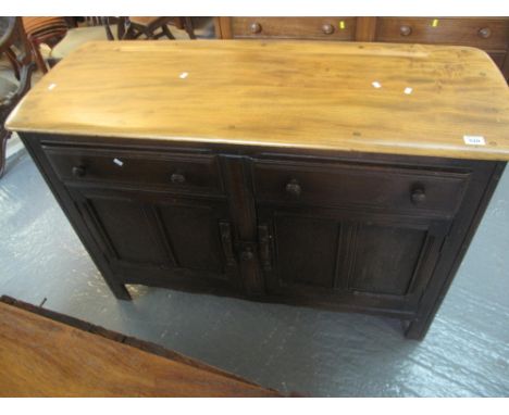 Elm Ercol sideboard having two drawers and two blind panelled fielded cupboards standing on stile feet, with red and gold Erc