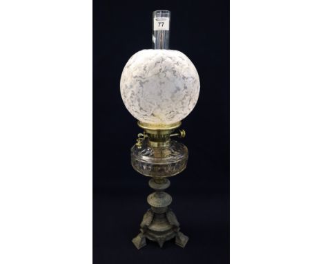 Early 20th Century brass double burner oil lamp with glass reservoir on a bronzed metal base, frosted glass shade and clear c