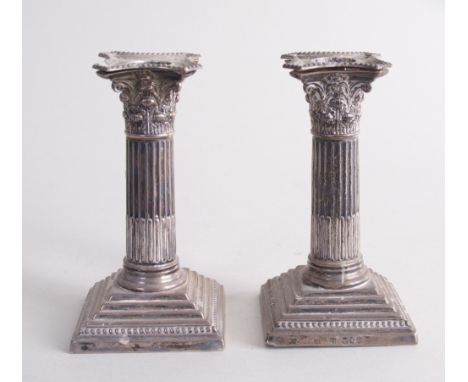 A pair of Victorian silver Corinthian column candlesticks, by William Hutton & Sons, London 1892, each with fluted columns, b