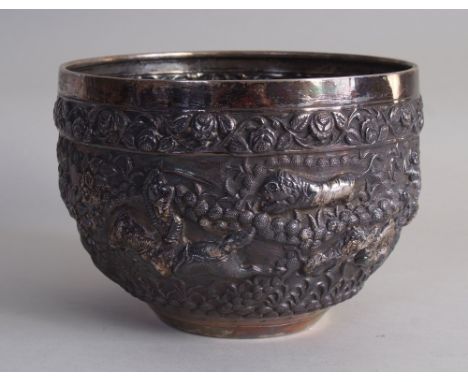 A late 19th century Burmese silver repoussé bowl, the tapering body depicting several hunting scenes of tiger, elephant, moun