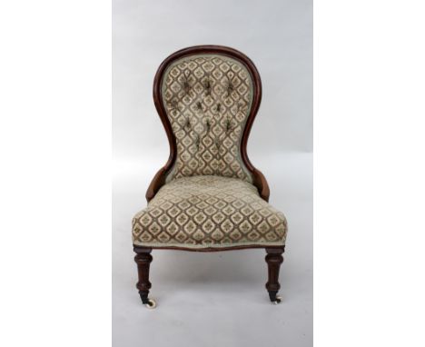 A Victorian mahogany button back nursing chair, on turned pilastered legs, with castors