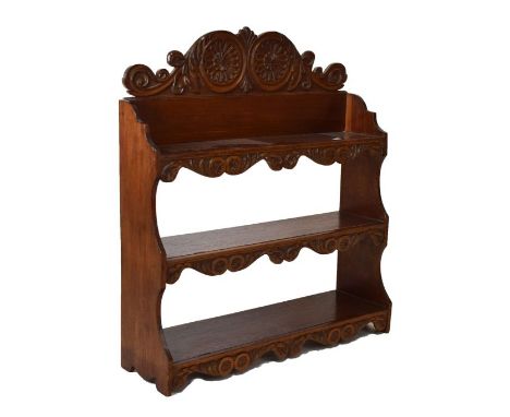 Mahogany three tier hanging shelves having carved scrolling crest and carved apron beneath each shelf, 63cm wide   Condition: