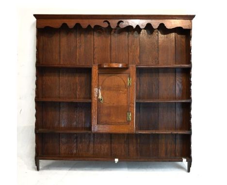 George III oak Delft/plate rack, the moulded corner with wavy valance and matching sides framing a central cupboard, long upp