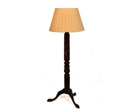 Carved walnut standard lamp with foliate stem on tripod support, together with a pleated silk shade   Condition: 