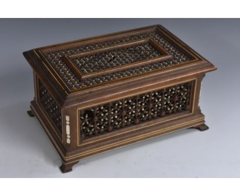 A Moorish hardwood rectangular table casket, the hinged cover and sides with typical turned and pierced screen work, ogee bra