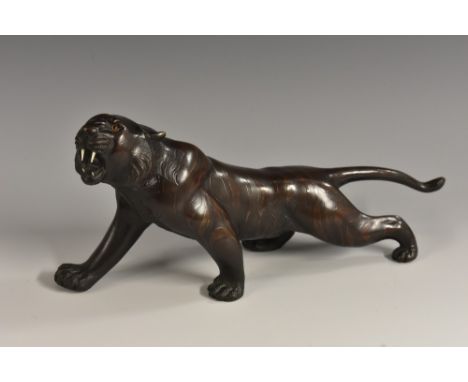 Japanese School (Meiji period), a two-tone brown patinated bronze, of a tiger, prowling, 25cm long