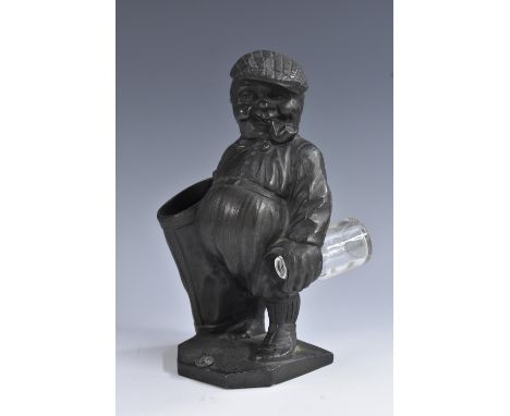 An early 20th century dark patinated spelter novelty spill holder, as a golf caddy in caricature, Peter Putter, he stands smo