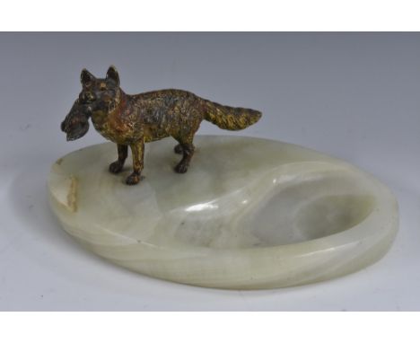 An early 20th century Austrian cold painted bronze, of a fox, he stands, holding captured fowl, mounted on an onyx dish, 17.5