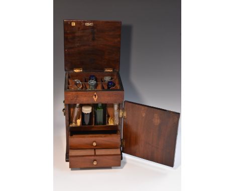 A George III mahogany apothecary cabinet, hinged cover above a door, enclosing an arrangement of compartments and drawers, br