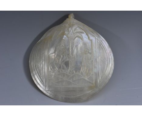 A Colonial mother of pearl pilgrim shell, carved in relief with the Flight into Egypt, 12cm wide