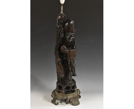 A large Chinese hardwood carving, of Shou Lao, the draped deity stands supported by his staff and holding the peach of longev