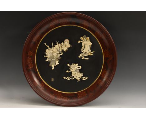 A large Japanese shibayama and lacquer charger, applied in ivory and mother of pearl with figures, the border with flowers on