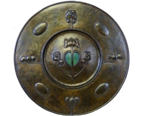 An Arts and Crafts copper wall plaque of circular form with beaten finish, the dished centre with anchor shaped embossed moti