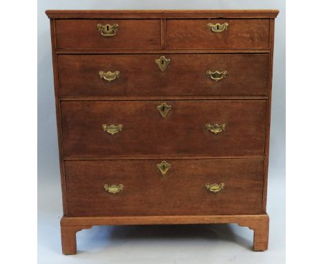A George III oak chest, of two short and three long graduated cockbeaded drawers with brass plate handles and escutcheons on 