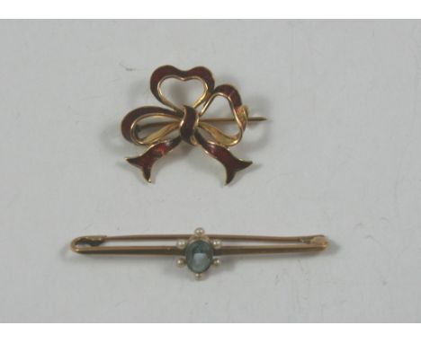 A late 19th century continental 14 k gold and red enamel bow brooch, applied 0.585 tab, and an Edwardian 15 ct gold aquamarin