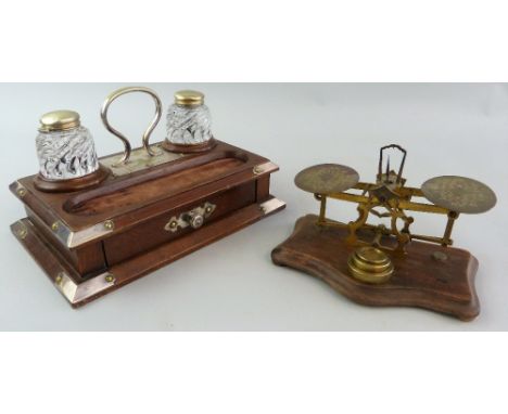 An early 20th century oak desk stand, of stepped oblong form with silver plated mounts and carrying handle, the top with two 