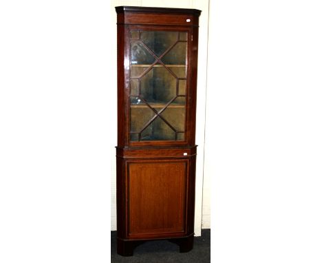 An Edwardian mahogany and strung floorstanding corner cupboard, with astragal glazed door enclosing three shelves above a cup