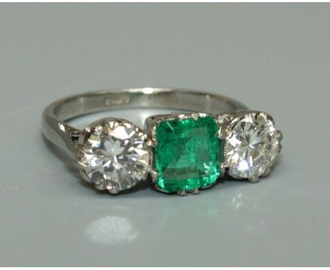 A Columbian emerald and diamond three stone ring, the central octagonal cut emerald weighing approx 0.91ct, as stated on acco