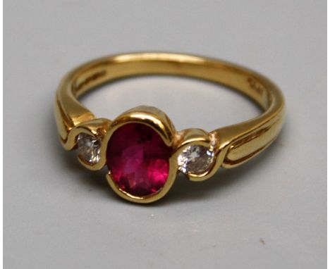 A pink tourmaline ring, the oval stone set between two diamonds on an 18ct gold shank, size O, 5gm