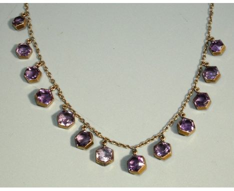 An early 20th Century amethyst set 9ct rose gold necklace, comprising hexagonal shaped amethyst stones in rub over settings, 