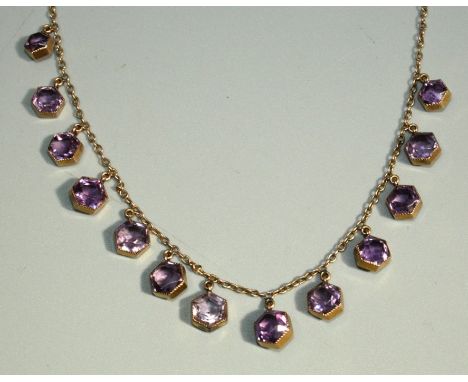 An early 20th Century amethyst set 9ct rose gold necklace, comprising hexagonal shaped amethyst stones in rub over settings, 