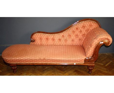 A Victorian walnut framed, button floral salmon upholstered chaise longue with swept back, scroll end, on turned lobed suppor
